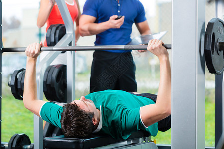 男人和他的私人健身教练在健身房用哑铃锻炼图片