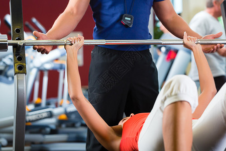 女人和她的健身教练在健身锻炼时用哑铃图片