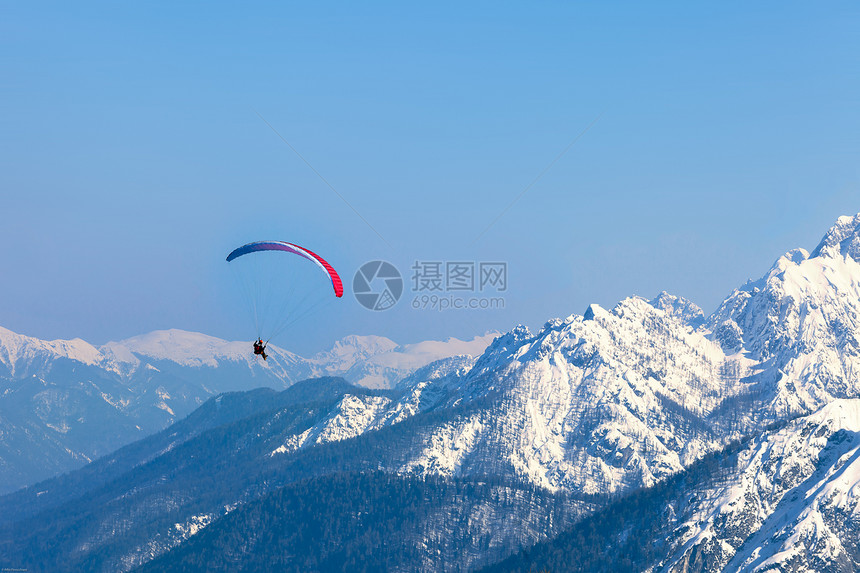 一个人和一个滑翔伞跳过意大利塔里西奥山的滑翔图片