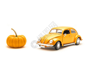演播室拍摄了橙色玩具汽车和小型南瓜图片
