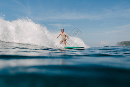 在冲浪板上滑动的潮流中年轻图片