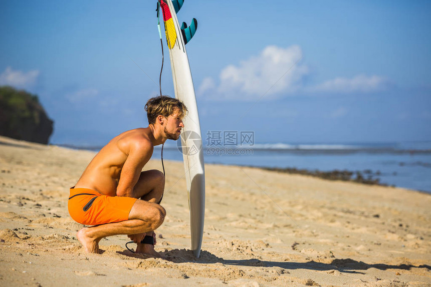 在海洋附近的沙滩上有冲浪板的图片