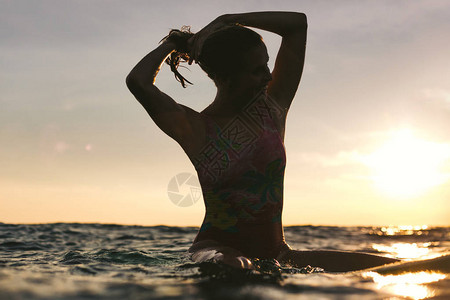 日落时坐在海洋冲浪板上重修头发背景图片
