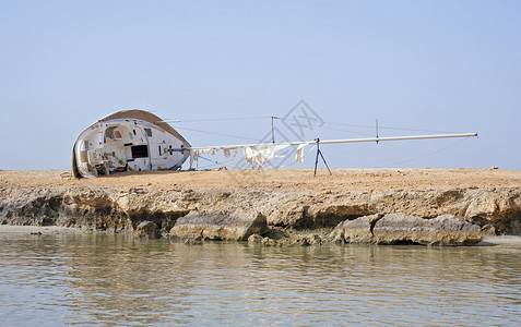 一艘废弃帆船的残骸被冲上岸边图片