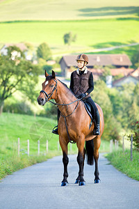 年轻女子在夏季骑马骑马骑马站在农图片