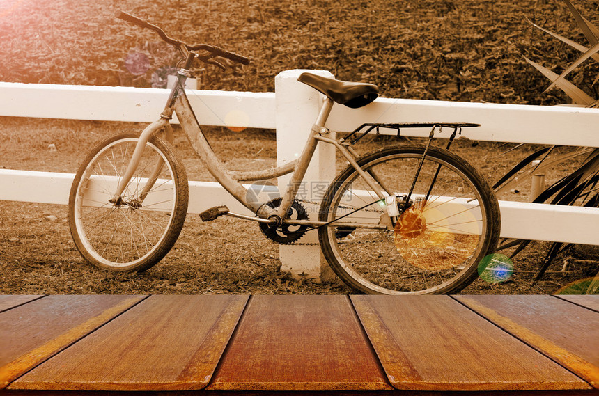 在晚上光背景与木桌的旧自行车图片