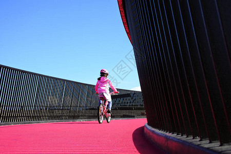 年轻女孩07岁在新西兰奥克兰的明亮粉红色车道骑自行车图片