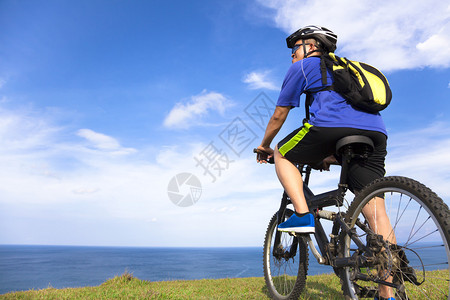 年轻人坐在山上骑着自行图片