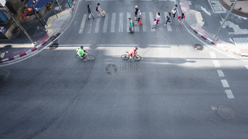 人们和自行车的空中观光正在穿过横行道和城市图片