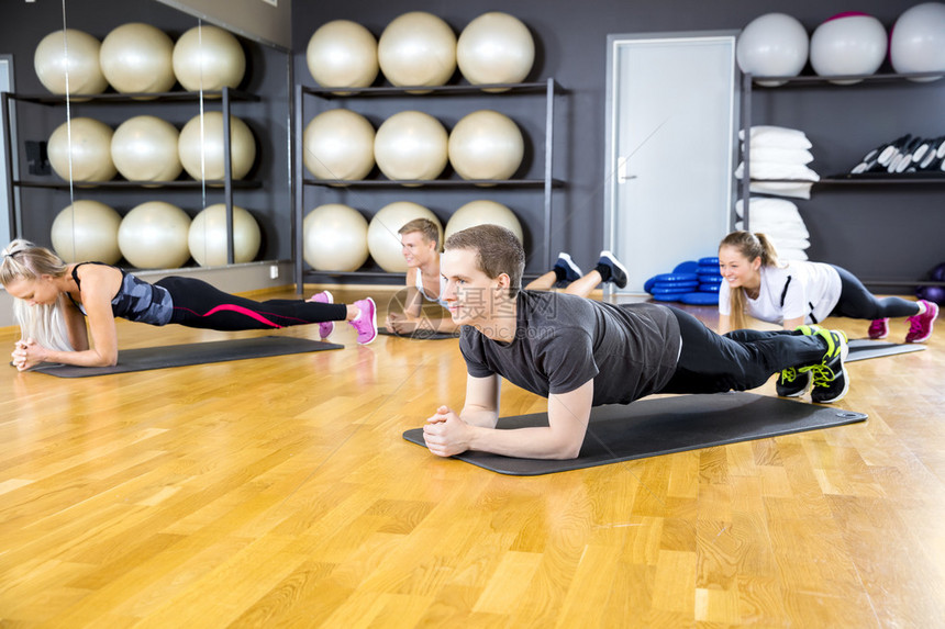 男女在健身房做木板锻炼在班上运动队在图片