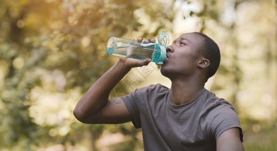 补水的好处年轻黑人男子在公园训练后从运动瓶图片