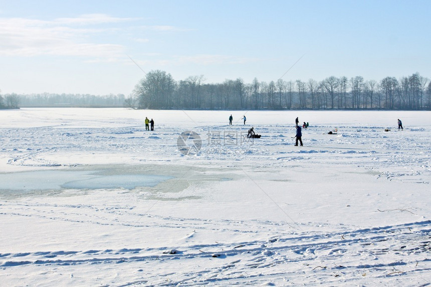 在白天阳光明媚的冰冻湖面上滑冰图片