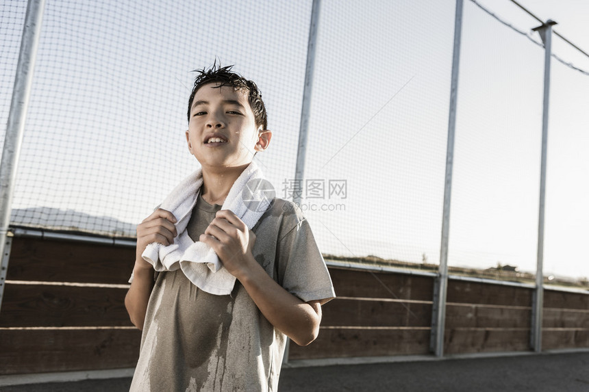 一个充满自信的男孩脖子上戴着毛巾经过了艰苦的练习准备图片