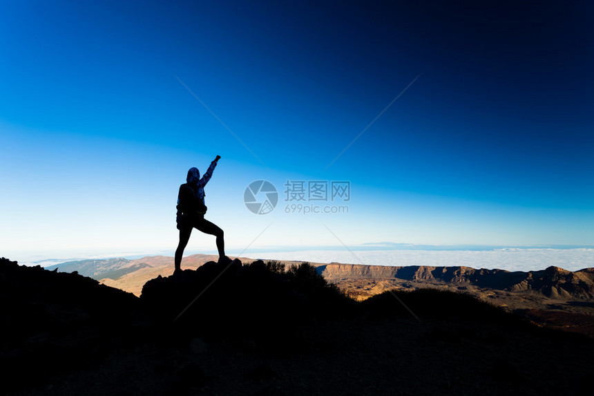 女人在山上成功远足攀登剪影图片