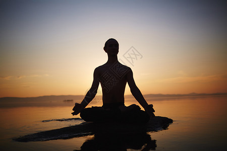 夕阳下沉思的年轻人剪影图片