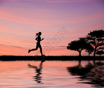 女慢跑者对着美丽的日落天空的光影环图片
