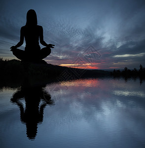 日落冥想期间的瑜伽练习者图片