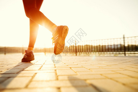 跑步者脚踏在路上紧贴鞋上女健身日出慢跑运高清图片