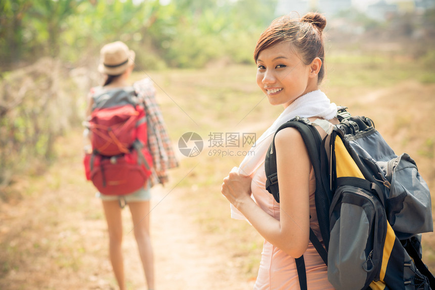 一位年轻背包客的肖像前景是背包而她的图片