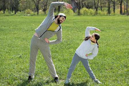 女儿和父亲在公园的草地上做运图片