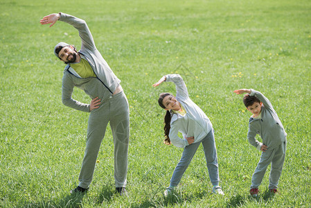 父亲带着女儿和子在草地上锻炼身体图片