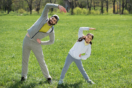 女儿和父亲在草地上做体育锻炼图片