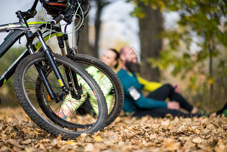 两辆山上自行车的近视秋天公园里坐着一对图片