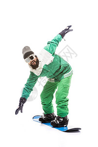 穿着滑雪板服装和眼镜的男子在滑雪板上滑动图片