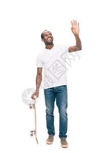 欢乐的非洲美国人拿着滑板挥手在白图片