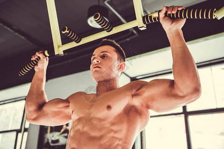 健壮的年轻肌肉运动员在健身房工作时图片