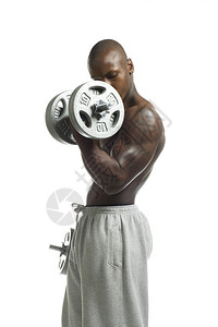 以白色背景与哑铃一起工作的非裔美国肌肉人图片