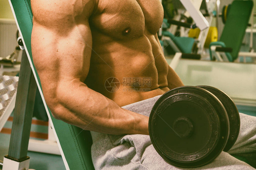 肌肉男健美运动员在健身房训练和摆肌肉图片