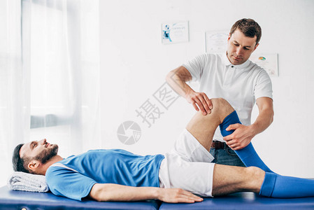 医院足球运动员长相英俊的生理治疗师在图片
