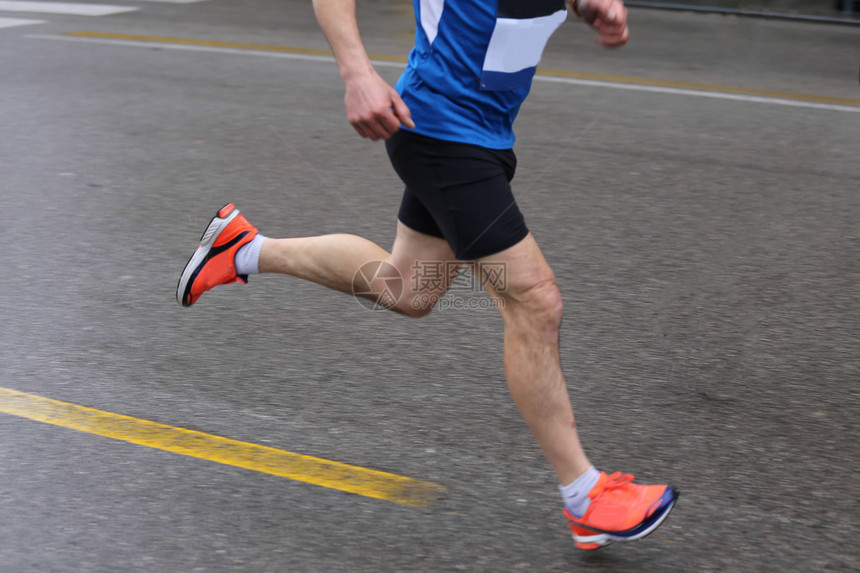 比赛中运动员的强壮肌肉腿部在雨图片