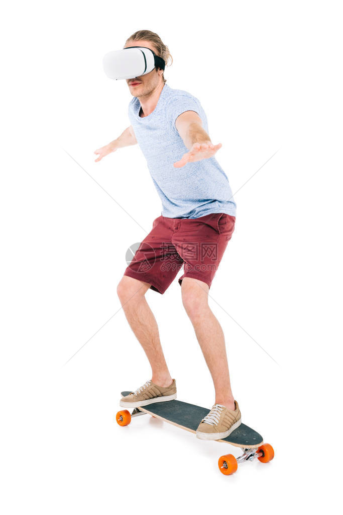 英俊的年轻男子在虚拟现实头盔滑板图片