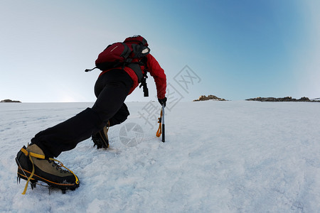 登山者在冰冷的斜坡上攀登陡峭的路线图片