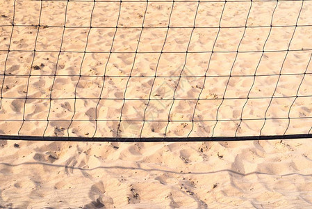 在沙地背景下玩海滩排球的黑格网图片
