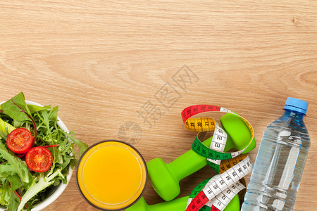 哑铃卷尺和木制背景的健康食品健身和健康使用复制空图片