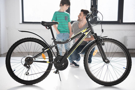 对新自行车和快乐父亲与儿子的完整全观互相看对图片