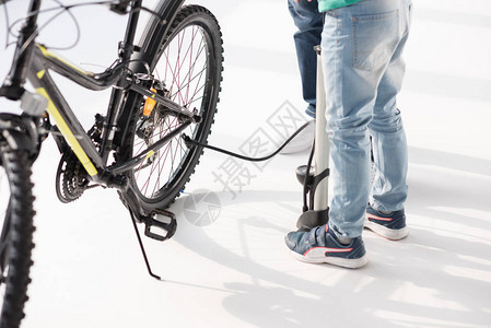父亲和儿子用白色泵充气的自行车轮胎图片