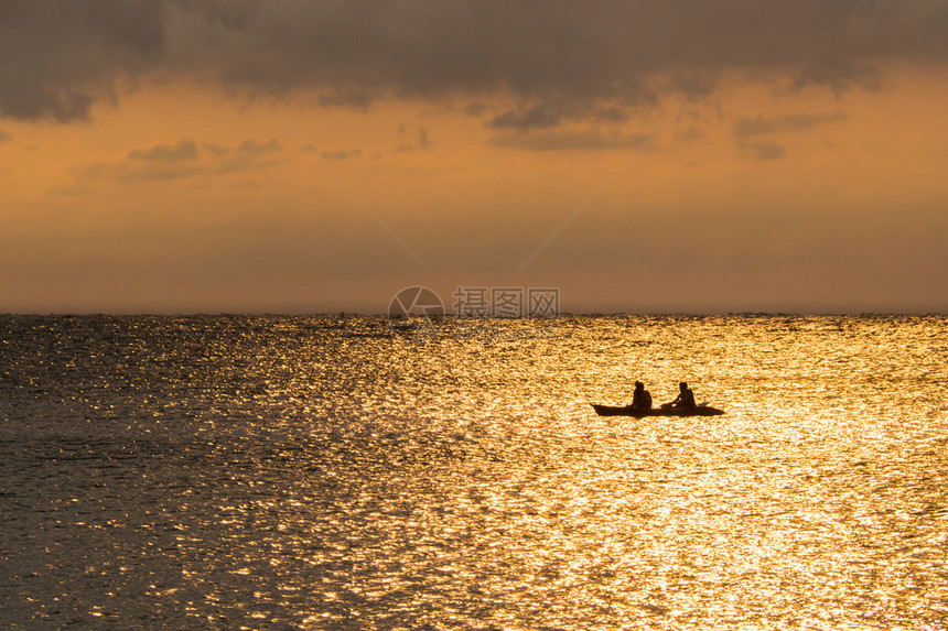 日落时乘独木舟的一对夫妇的休眠轮图片