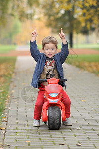 可爱的小骑自行车的人在路上骑摩托车玩具摩图片