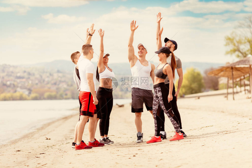 一群快乐的年轻朋友在沙滩上运动前先图片