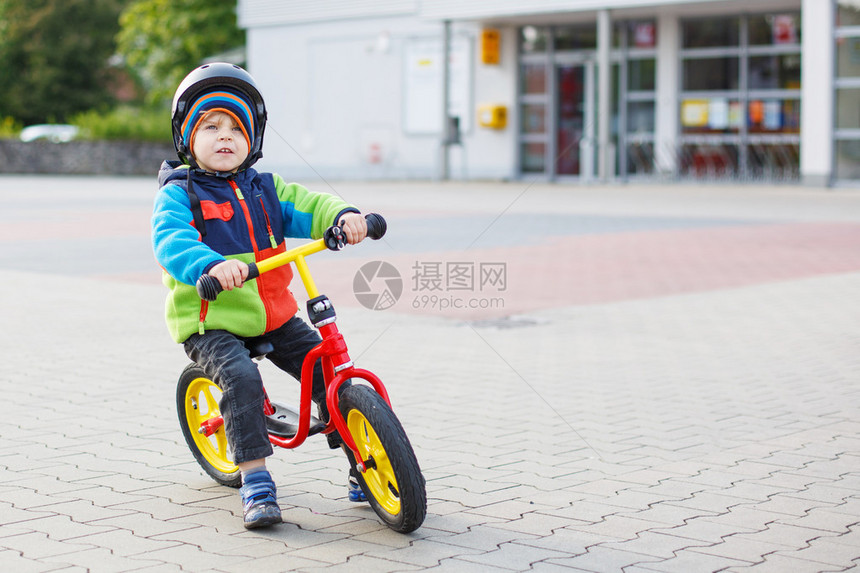 小孩在城里学骑着第一辆自行车图片