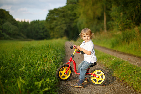 小孩在夏天森林里学会骑着第一图片