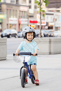 在户外道路上骑着平衡自行车骑着平衡自行车的微笑小男孩肖像图片