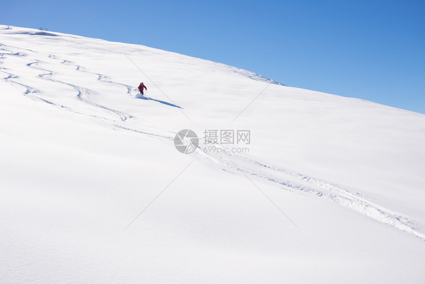 一个人在意大利阿尔卑斯山的雪坡上滑下脚踏板图片