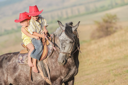 两个快乐的小孩骑马在农场户外画像图片
