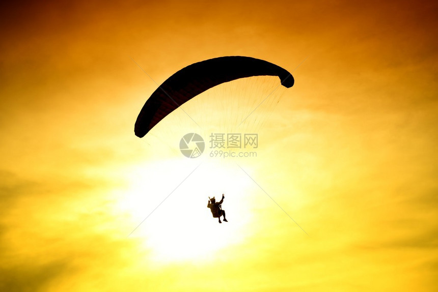 降落伞在日落背景上的剪影图片
