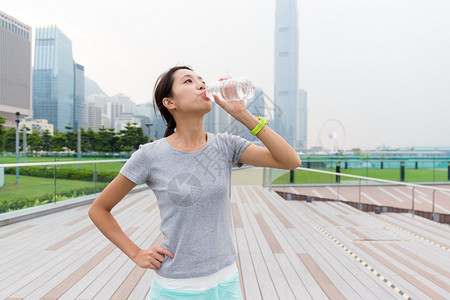 亚洲年轻女子跑步后喝水图片
